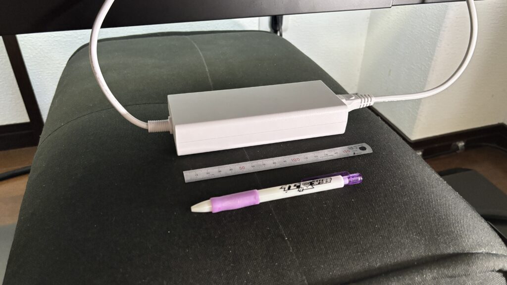 GA32V1M Maxの電源アダプタ。定規とペンを並べて大きさを比較