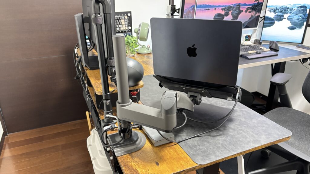 モニターアームに付けたラップトップホルダーでMacBook Airを吊るしたデスク