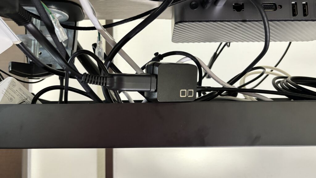 デスクのフレームに付けた電源タップに横から挿したNovaPort DUO 65W